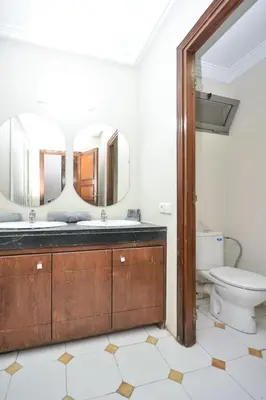 a bathroom with a toilet and a mirror at Cozy 2 BR Gauthier Oasis in Casablanca