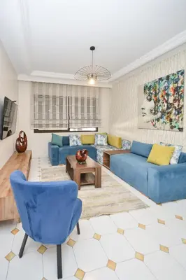 a living room with blue couches and a table at Cozy 2 BR Gauthier Oasis in Casablanca