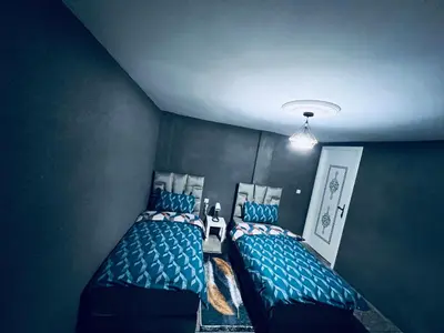 two beds in a room with blue at Organizado apartamento 2 in Mediouna