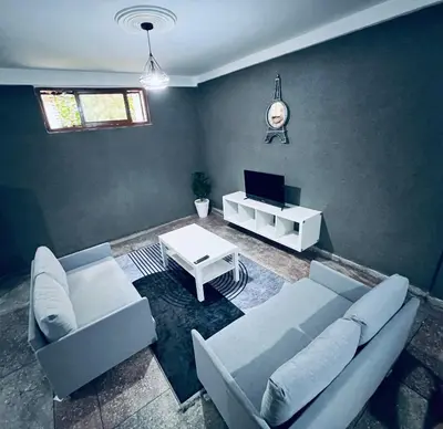 a living room with a couch and a tv at Organizado apartamento 2 in Mediouna