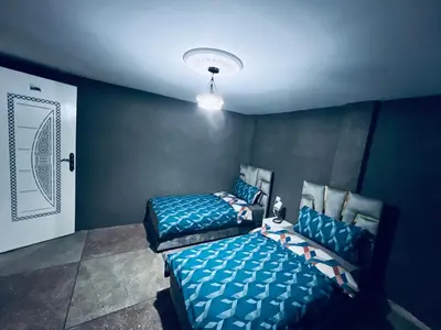 two beds in a room with blue walls at Organizado apartamento 2 in Mediouna