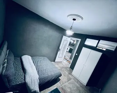 a bedroom with a bed and a door and a light at Organizado apartamento 2 in Mediouna