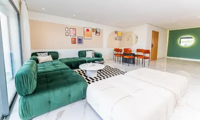 a living room with a green couch and a table at The lodge Residence by Goodmove - Hay Riad in Rabat