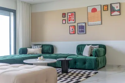 a living room with two green couches and a table at The lodge Residence by Goodmove - Hay Riad in Rabat