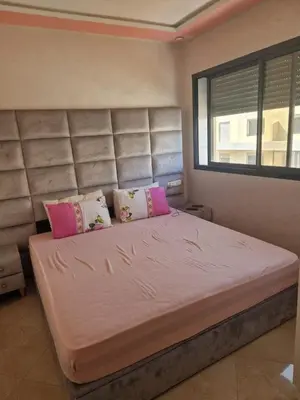 a bedroom with a large bed with pink pillows at الشروق in Pont Blondin