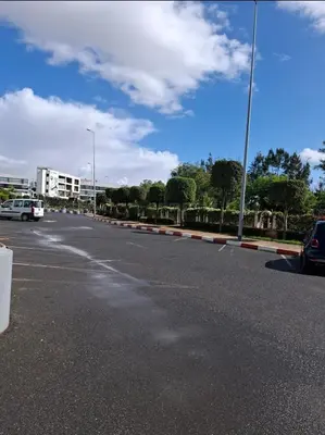 an empty street with a car driving down a road at La perle in Pont Blondin