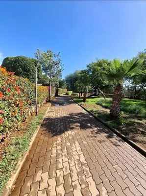 a brick road in a park with trees and flowers at La perle in Pont Blondin