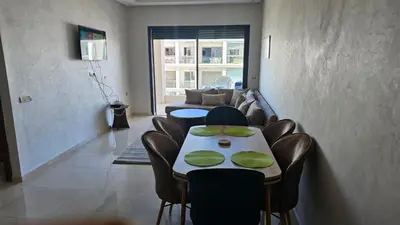 a living room with a table and chairs and a couch at Voyager in Souk el Had