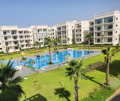 a large apartment building with a large swimming pool at Voyager in Souk el Had