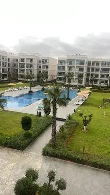 a large apartment building with a large swimming pool at Voyager in Souk el Had
