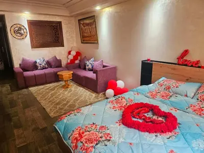 a bedroom with a bed with a red flower on it at Mi mini estudio 3 in Rabat