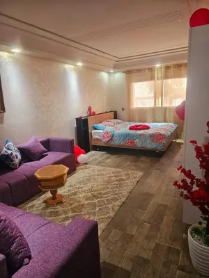 a living room with a purple couch and a bed at Mi mini estudio 3 in Rabat