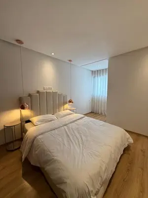 a bedroom with a large white bed with two lamps at NEW apartment heart of Rabat city center in Rabat