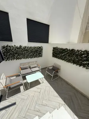 a room with chairs and a table and a wall with plants at NEW apartment heart of Rabat city center in Rabat