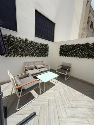 a room with chairs and a table and a wall at NEW apartment heart of Rabat city center in Rabat