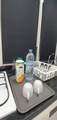 a counter with a bottle of water and a cutting board at Cozy Apartement B-House Airport in Berrechid