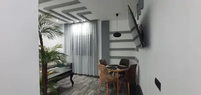 a dining room with a table and chairs and a staircase at Cozy Apartement B-House Airport in Berrechid