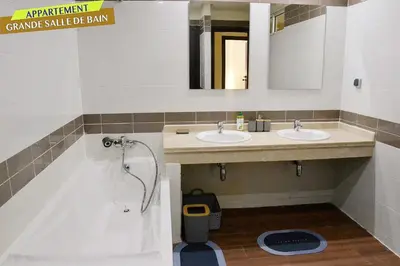 a bathroom with two sinks and a bath tub at Bel Appartement à louer à Mansouria in Pont Blondin
