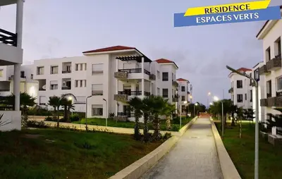 a row of white apartment buildings on a street at Bel Appartement à louer à Mansouria in Pont Blondin