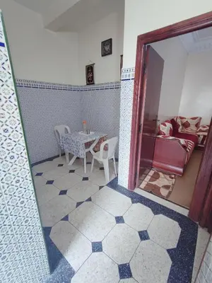 a room with a table and chairs and a living room at de Luxe in Rabat