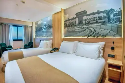 a hotel room with two beds and a painting on the wall at ADAY Hotel Casablanca in Casablanca