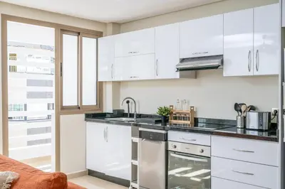 a kitchen with white cabinets and a sink at Very Charming Apartments with balcony, Haut Agdal in Rabat