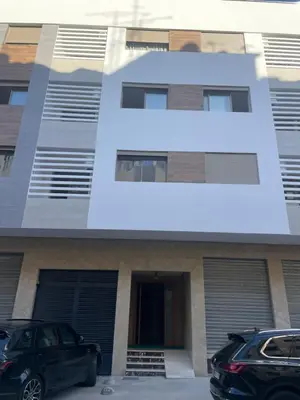 a building with two cars parked in front of it at Very Charming Apartments with balcony, Haut Agdal in Rabat