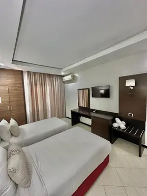 a hotel room with two beds and a television at Oscar Hotel in Rabat
