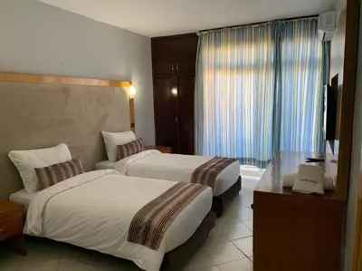 a hotel room with two beds and a television at Oscar Hotel in Rabat