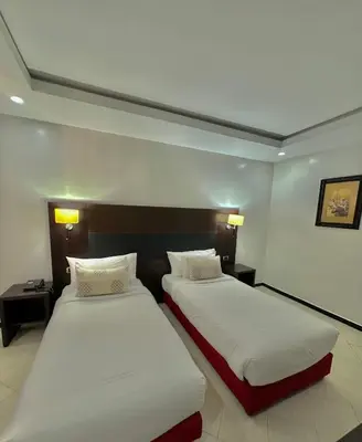 two beds in a hotel room with white sheets at Oscar Hotel in Rabat