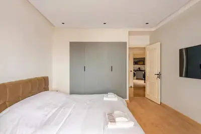 a bedroom with a bed and a flat screen tv at Luxury Central 3BR 5min from Beach & Shopping in Casablanca