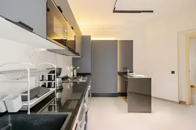 a kitchen with stainless steel appliances and black counter tops at Luxury Central 3BR 5min from Beach & Shopping in Casablanca