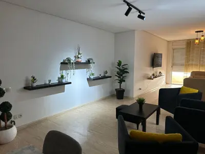 a living room with a couch and a table at Appartement haut standing Mohammedia Parc in Mohammedia
