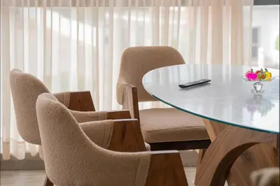 a table with two chairs and a table with a bowl of flowers at Appart Moderne Tamaris Piscine, Plage et Confort in Tamaris