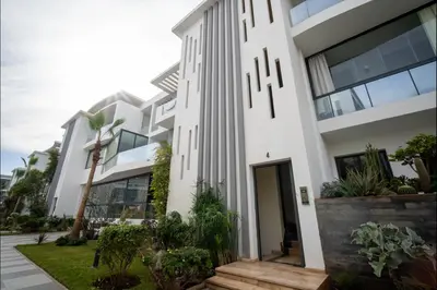 a white building with a clock on it at Appart Moderne Tamaris Piscine, Plage et Confort in Tamaris
