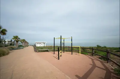 a playground on a sidewalk next to a fence at Appart Moderne Tamaris Piscine, Plage et Confort in Tamaris