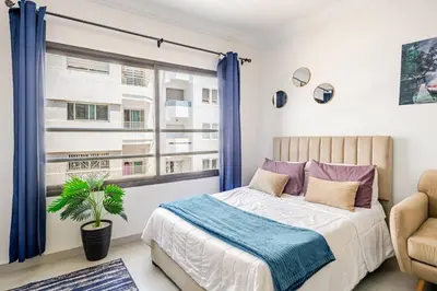 a bedroom with a bed and a window at Cozy studio moderne Agdal in Rabat