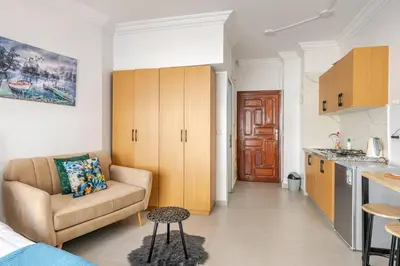 a living room with a couch and a kitchen at Cozy studio moderne Agdal in Rabat