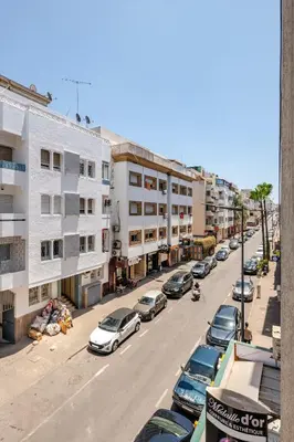 a city street with parked cars and buildings at Cozy studio moderne Agdal in Rabat