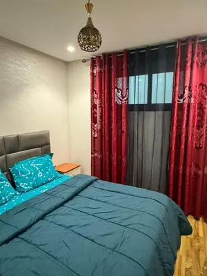 a bedroom with a bed with red curtains and a chandelier at Emma's Duplex in Casablanca