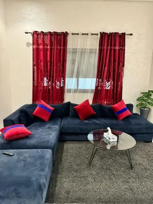 a blue couch in a living room with red curtains at Emma's Duplex in Casablanca