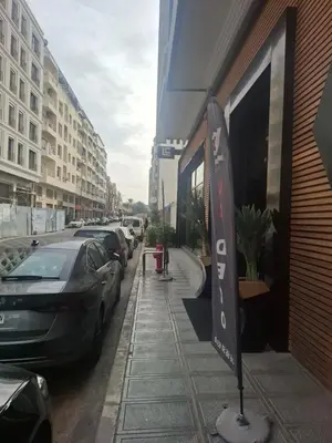 a street sign in front of a building with parked cars at Emma's Duplex in Casablanca