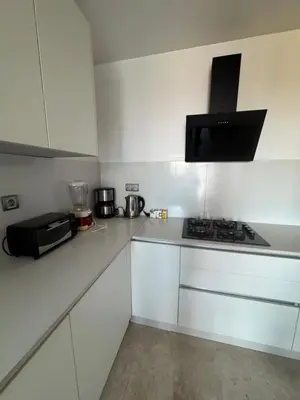 a white kitchen with a stove and a microwave at Appartement 3 chambres moderne a californie Casablanca in Casablanca