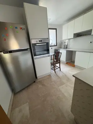 a kitchen with a stainless steel refrigerator and white cabinets at Appartement 3 chambres moderne a californie Casablanca in Casablanca