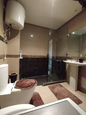 a bathroom with a shower and a toilet and a sink at Cozy 1-BR with Large Terrace in Casablanca