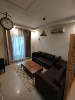 a living room with a couch and a clock at Cozy 1-BR with Large Terrace in Casablanca