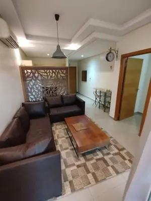 a living room with a leather couch and a table at Cozy 1-BR with Large Terrace in Casablanca