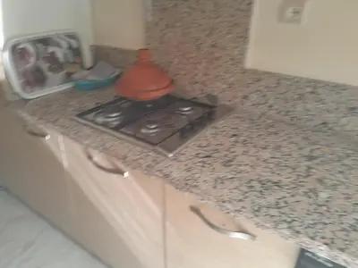 a kitchen counter with a stove on a counter top at Beautiful apartment with pool & beach nearby in Bouznika