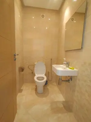 a bathroom with a toilet and a sink at Beautiful apartment with pool & beach nearby in Bouznika