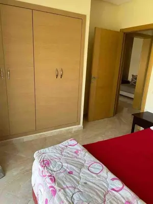 a bedroom with a bed and a large closet at Beautiful apartment with pool & beach nearby in Bouznika